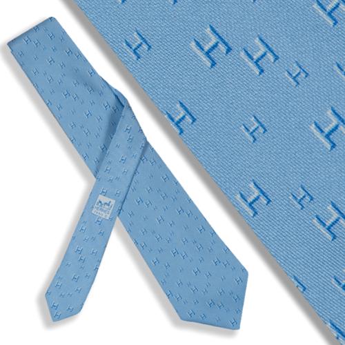 Corbata Hermés logotipo sobre fondo azul.