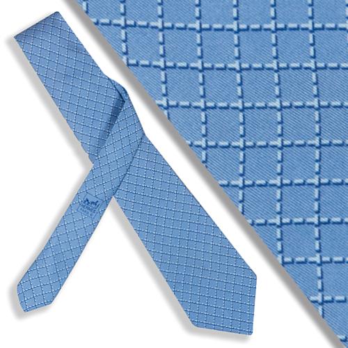 Corbata Hermés cuadrícula sobre fondo azul.