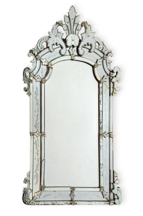 Espejo rectangular de perfil recortado en vidrio de Murano, con decoración grabada y crestería recortada con forma de hojas.