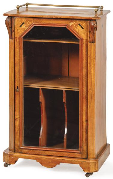 Mueble musiquero eduardino en madera de nogal, con decoración de marquetería de motivos vegetales, con una puerta central abatible que al abrirse revela en su interior un cajón y varios compartimentos.