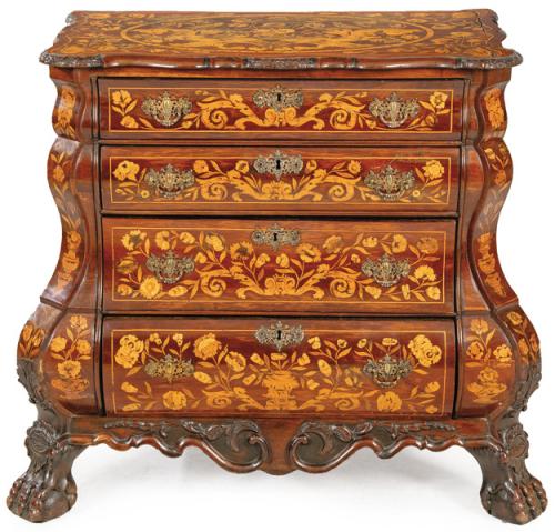 Cómoda rococó de perfil sinuoso en madera de nogal, con decoración de márquetería de época posterior de ramas y flores en maderas frutales. Tiradores y escudos de cerradura en bronce. 