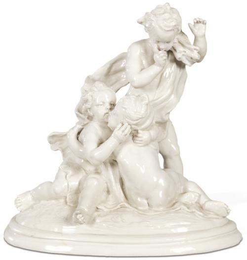 Grupo de figuras en porcelana esmaltada en blanco de Capodimonte firmado en la base L. Badessi. Representando a un putto de pie con gavilla de ramas, y sentados en la base dos putti abrazados.