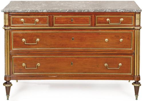 Cómoda Luis XVI en madera de caoba. Sobre patas estriadas descansa un cuerpo de dos grandes cajones superpuestos y tres a la cintura, con tiradores en latón. Cubierta en mármol gris.
