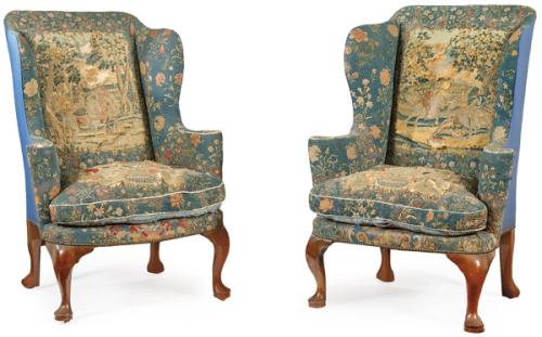 Pareja de sillones Jorge II, con patas en madera de nogal tallada, tapicería bordada con motivos florales y tela azul en la trasera.