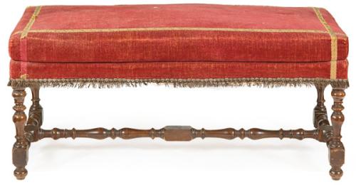 Banqueta estilo Luis XIII, con patas y chambranas en madera de nogal torneada, y tapicería de terciopelo granate.