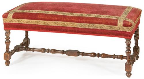 Banqueta estilo Luis XIII, con patas y chambrana en "H" en madera de nogal torneada, con tapicería de terciopelo rojo.