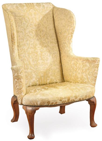 Sillón Jorge II  tapizado en damasco color ocre y con patas cabriolé en madera de nogal.