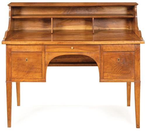 Mesa de escritorio Carlos IV en madera de nogal, sobre la tapa rectangular, se sitúan una serie de compartimentos. En el frente, un cajón corto flanqueado por dos cajones cuadrados con ojos de cerradura en latón. España, principios S. XIX