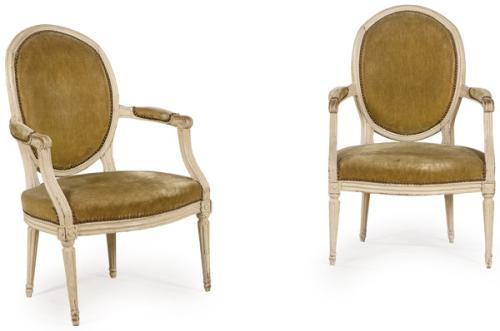 Pareja de butacas Luis XVI en madera tallada y pintada de blanco, con tapicería de tela de época posterior.