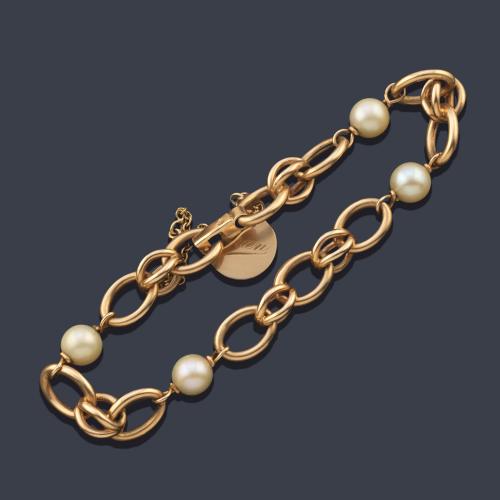 Pulsera con perlas y eslabones ovalados en oro amarillo de 18K.