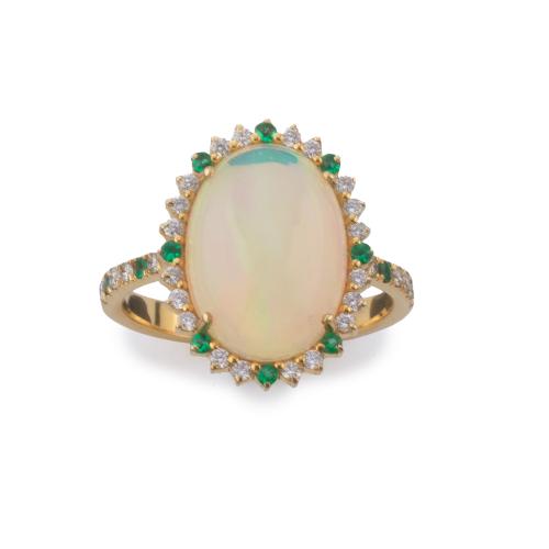 Anillo con ópalo talla cabujón de aprox. 3,26 ct con orla de brillantes de aprox. 0,27 ct y esmeraldas de aprox. 0,14 ct en total.
