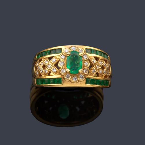  Anillo con esmeralda talla oval de aprox. 0,30 ct con diseño calado con brillantes y banda de esmeraldas calibradas.