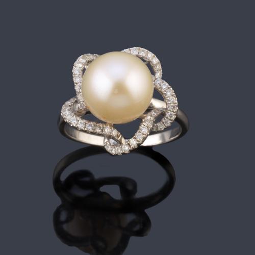 Anillo con perla central de aprox. 10,30 mm con orla al aire ondulada con brillantes de aprox. 0,34 ct en total.