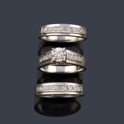 Tres anillos, dos media alianzas con banda de brillantes y el tercero con brillante central de mayor tamaño y diamantes en ambos lados.