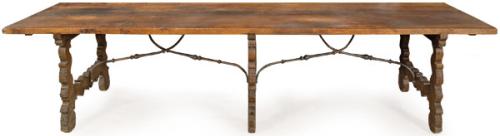 Mesa de comedor siguiendo modelos españoles del S. XVII, con tablero rectangular de roble, sobre patas recortadas en forma de lira y fiadores de hierro abalaustrados en "S". España, finales S. XIX-XX