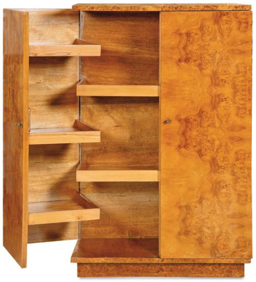 Armario bajo en madera de raíz de arce, con dos puertas abatibles en ángulo recto, revelando un interior al abrirse con baldas. Tiradores de latón. 