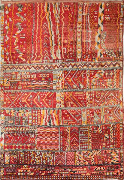 Alfombra marroquí reversible con dibujos geométricos rojos y naranjas sobre fondo blanco.