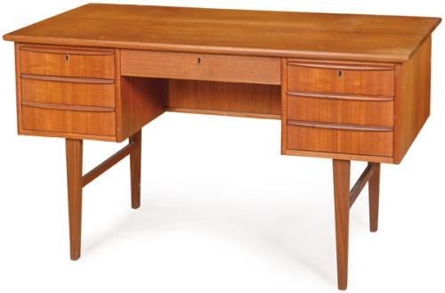 Mesa escritorio en madera de teca, con un cajón corto en el centro y tres cajones a cada lado, con tirador de madera, sobre patas unidas por chambranas. Dinamarca, años 60