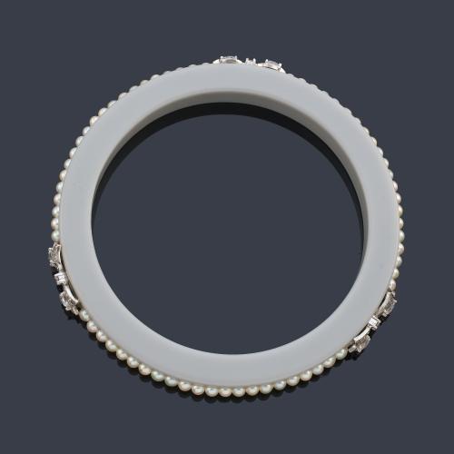 Pulsera rígida con banda de perlitas aljófar con tres motivos de lazada con diamantes talla rosa y holandesa de aprox. 0,53 ct en total. Años '30.