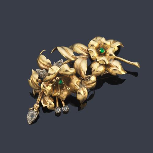 Broche con diseño floral con esmeraldas en montura de oro amarillo de 18K.