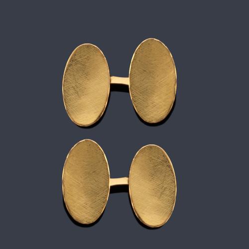 Gemelos con diseño oval y motivo rallado en montura de oro amarillo de 18K. Años '70.