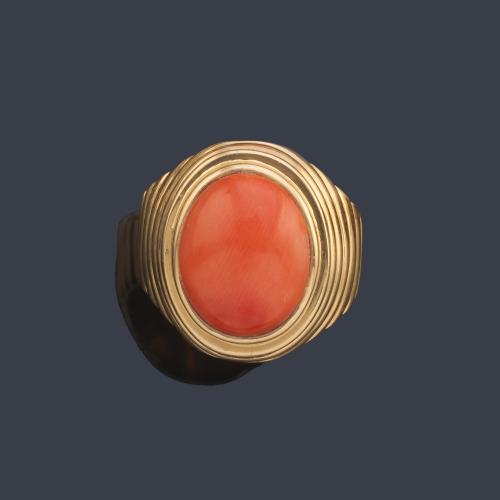 Anillo con coral talla cabujón en montura gallonada en oro amarillo de 18K.