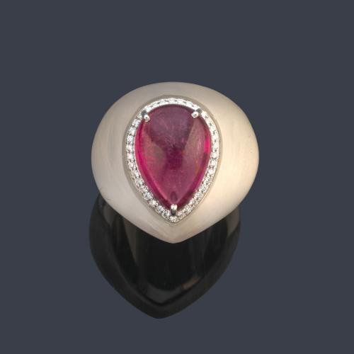 Anillo bombé con rubelita talla cabujón de aprox. 6,88 ct y orla de brillantitos sobre pieza de cristal de roca.