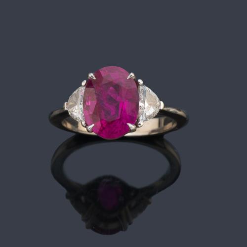 Anillo con rubí talla oval de aprox. 3,51 ct con dos diamantes talla triángulo de aprox. 0,42 ct en total. Certificado GRS Gemreserch SwissLab.