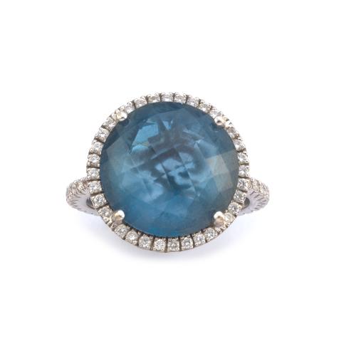 Anillo con topacio 'London Blue' facetado con orla y banda de brillantes de aprox. 0,58 ct en total.