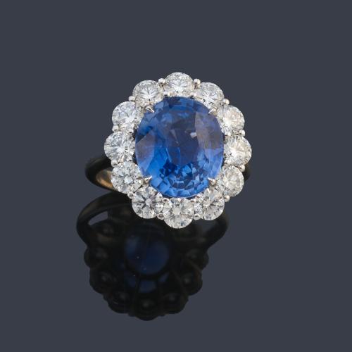 Anillo con zafiro talla oval de aprox. 4,89 ct con orla de brillantes de aprox. 1,22 ct en total. Certificado Bellerophon Gemlab.