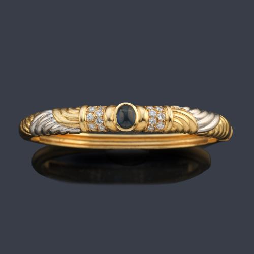 Pulsera rígida con zafiro talla cabujón y dos bandas de brillantes en ambos lados.