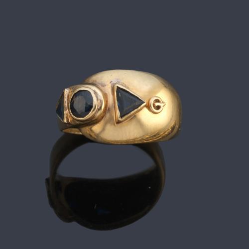 Anillo con dos zafiros talla triángulo y redonda en montura de oro amarillo de 18K.