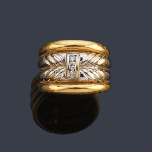 Anillo con cuatro aros en oro blanco y amarillo de 18K con tres brillantes al centro.