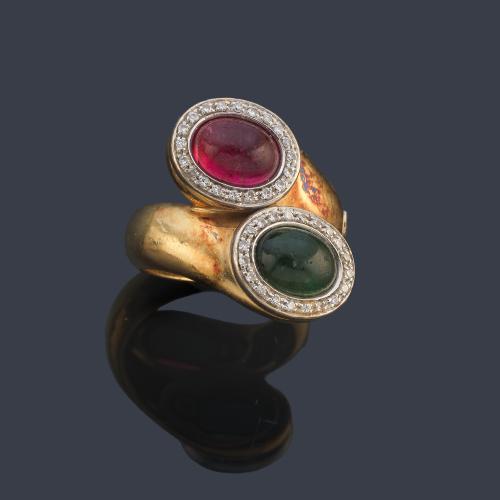 Anillo 'tú y yo' con turmalina verdelita y rubelita talla cabujón con orla de diamantes.