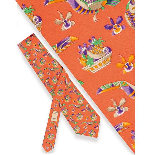 Corbata Leonard con cestas de frutas, papagayos y orquídeas sobre fondo naranja.
