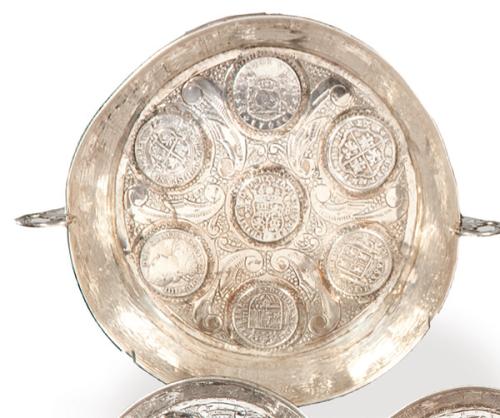 Cuenco de plata con marcas apócrifas, de estilo colonial, con decoración de monedas y asas.