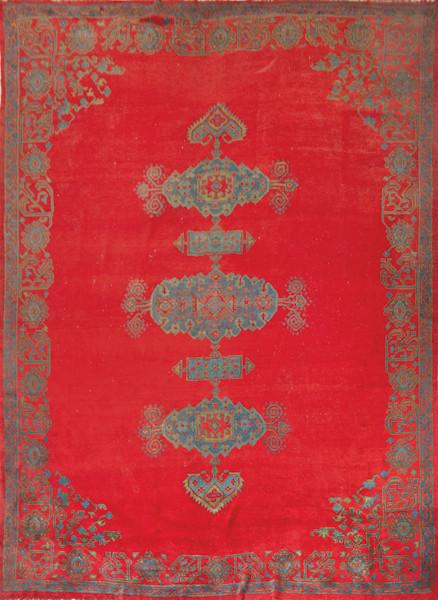 Gran alfombra roja con decoración geométrica en azul.