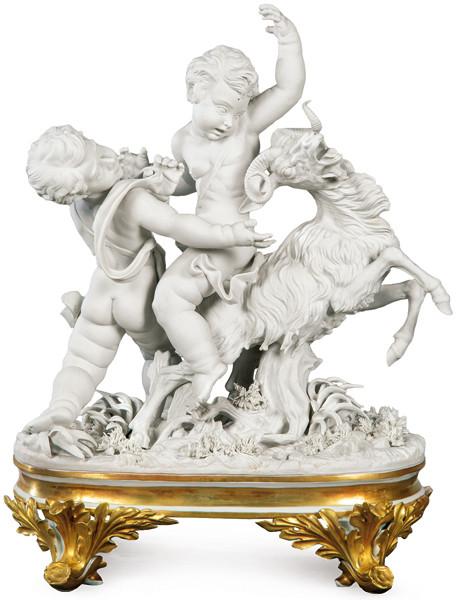 Grupo escultórico "Anatolia", representando dos niños con cabra sobre suelo con vegetación, en biscuit de Algora serie limitada.