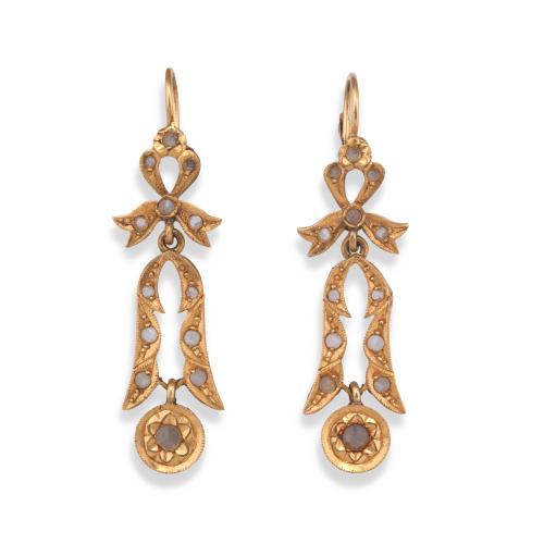 Pendientes largos con diseño en forma de campana con diamantes talla rosa y remate en forma de roseta.