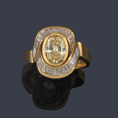  Anillo con diamante 'fancy yellow' talla oval de aprox. 1,20 ct con dos bandas de diamantes talla trapecio de aprox. 1,22 ct en total.