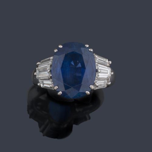  Anillo con zafiro talla oval de aprox. 11,00 ct con diamantes talla trapecio en ambos lados.