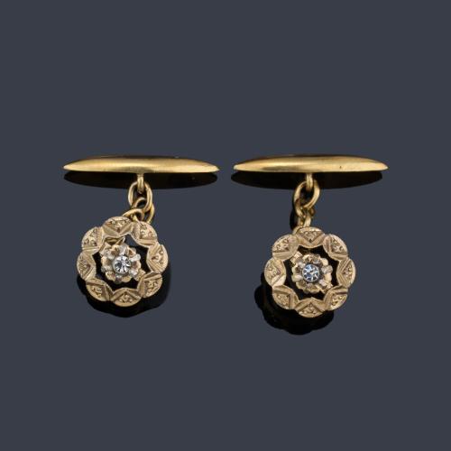 Gemelos con diseño de rosetón con centro en símil de diamante en montura de oro amarillo de 18K.