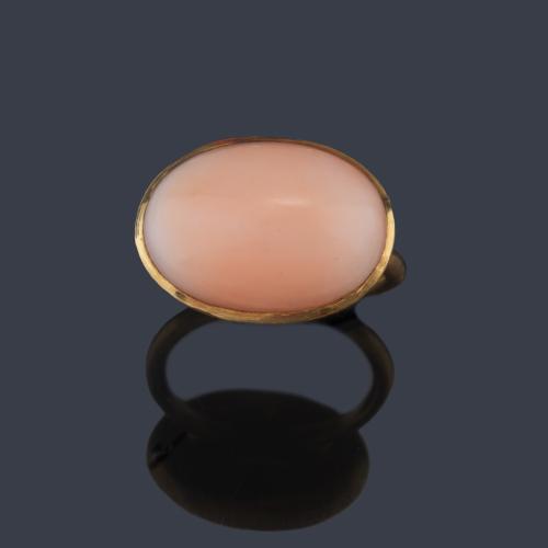 Anillo con pieza de coral rosa talla cabujón en montura de oro amarillo de 18K.