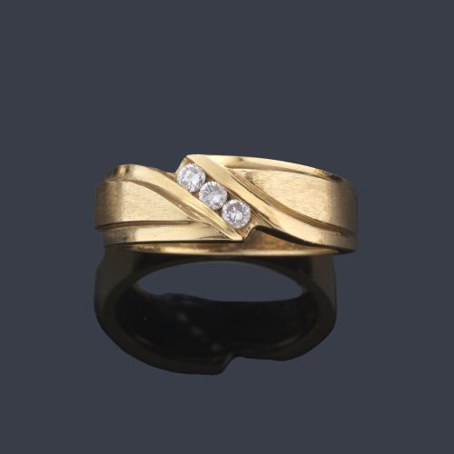  Anillo con tres brillantes centrales en montura de oro amarillo de 14K.
