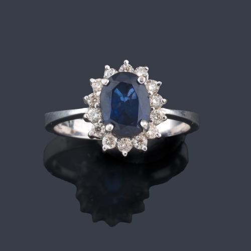  Anillo con zafiro central talla oval de aprox. 1,00 ct con orla de brillantes.