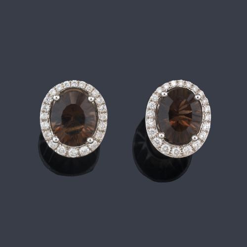 Pendientes cortos con pareja de cuarzos ahumados talla oval con orla de brillantes.