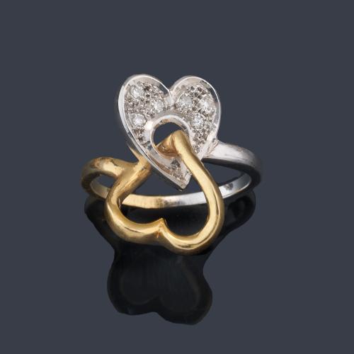 Anillo con doble motivo de corazón, uno de ellos con pavé de diamantes talla 8/8 en montura de oro blanco y amarillo de 18K.