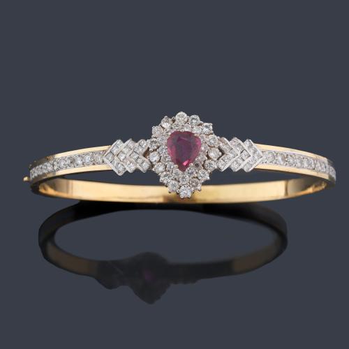 Pulsera rígida con rubí central talla perilla de aprox. 0,70 ct con doble orla de brillantes y diamantes talla princesa en ambos brazos de aprox. 2,50 ct en total.