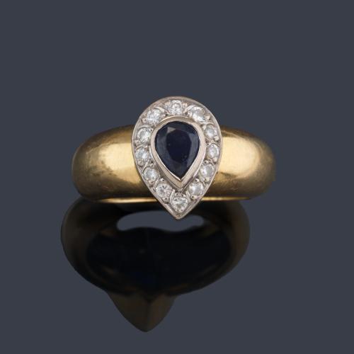 Anillo con zafiro talla perilla y orla de brillantitos en montura de oro amarillo de 18K.