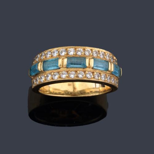 Anillo con banda central con cinco topacios talla baguette y dos bandas de brillantes.